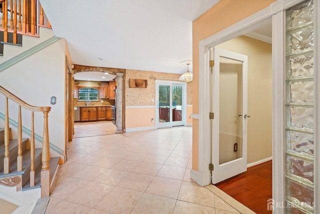 entryway featuring decorative columns, stairs, baseboards, and light tile patterned flooring