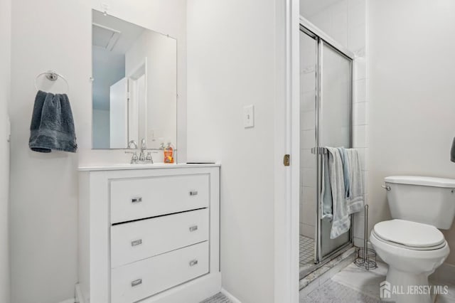 bathroom featuring a stall shower, toilet, vanity, and baseboards