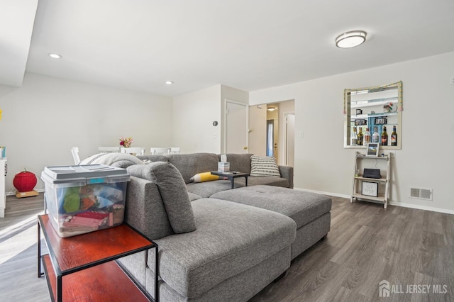 living room featuring wood finished floors, recessed lighting, and baseboards