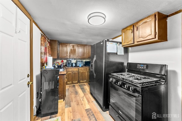 809 Summerfield Ave, South Amboy, NJ 08879 - kitchen with black appliances, light wood-style floors, and brown cabinetry
