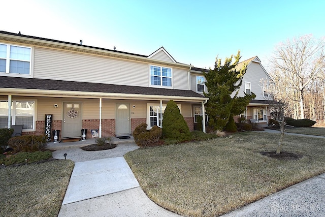 townhome / multi-family property with brick siding and a porch