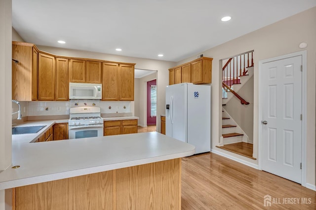 27 Rue Chagall, Franklin, NJ 08873 - kitchen featuring white appliances, light countertops, light wood-type flooring, backsplash, and a peninsula