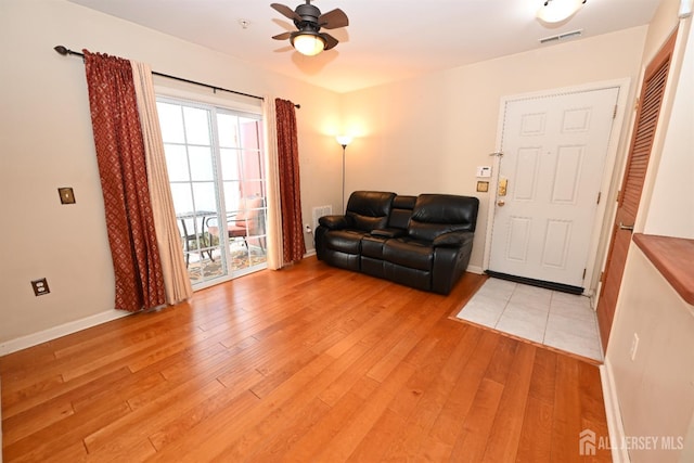 living room with ceiling fan and light hardwood / wood-style floors