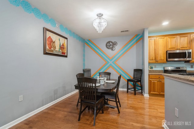 dining area with a chandelier and light hardwood / wood-style floors