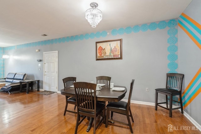 dining space with an inviting chandelier and light hardwood / wood-style floors