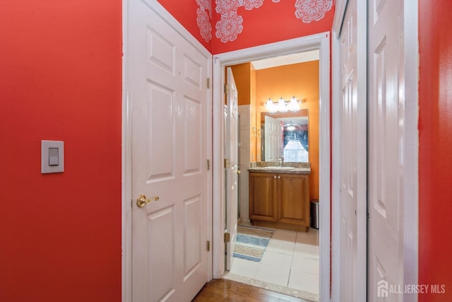 hall featuring tile patterned flooring and sink