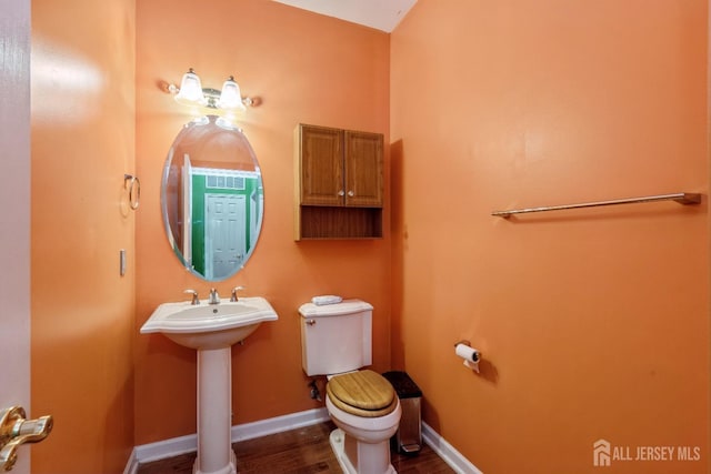 bathroom featuring hardwood / wood-style flooring and toilet