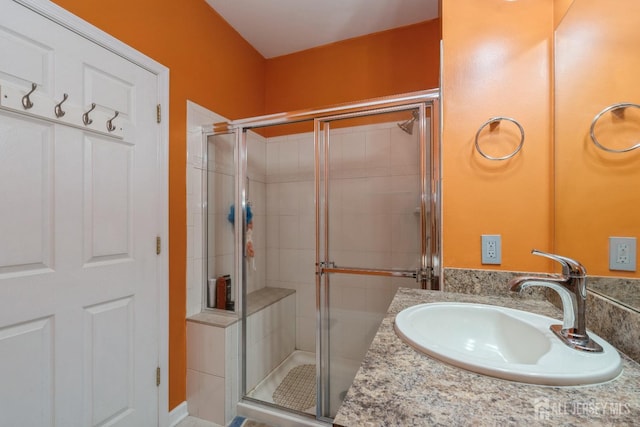 bathroom featuring vanity and an enclosed shower