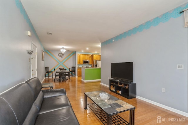 living room featuring a notable chandelier and light hardwood / wood-style floors