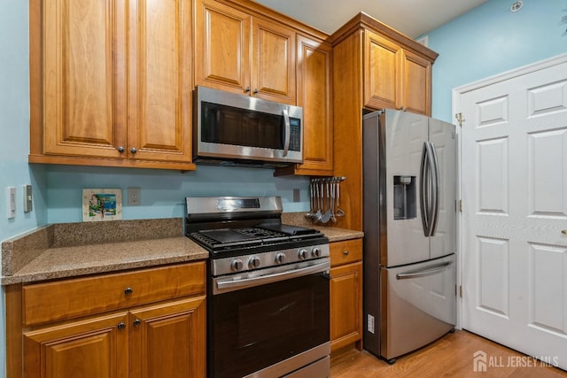 kitchen with stainless steel appliances and light hardwood / wood-style flooring