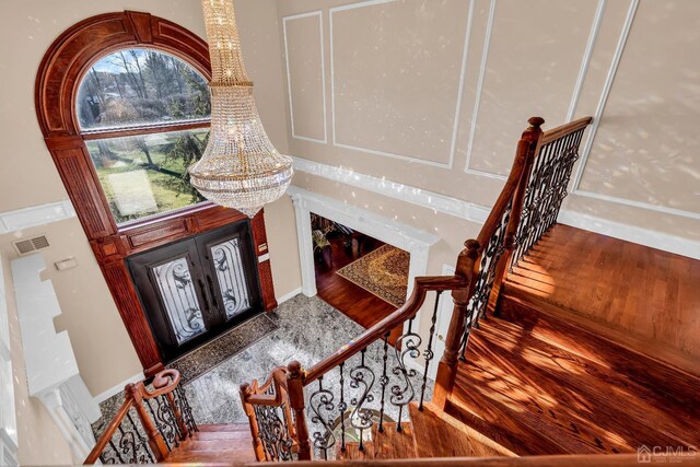 entryway with wood-type flooring and a chandelier