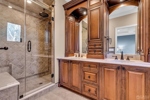 bathroom with double vanity, a stall shower, and a sink