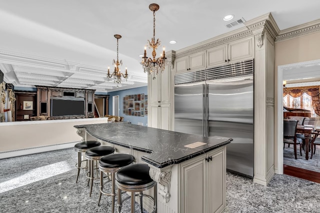 kitchen featuring recessed lighting, visible vents, granite finish floor, cream cabinets, and stainless steel built in refrigerator