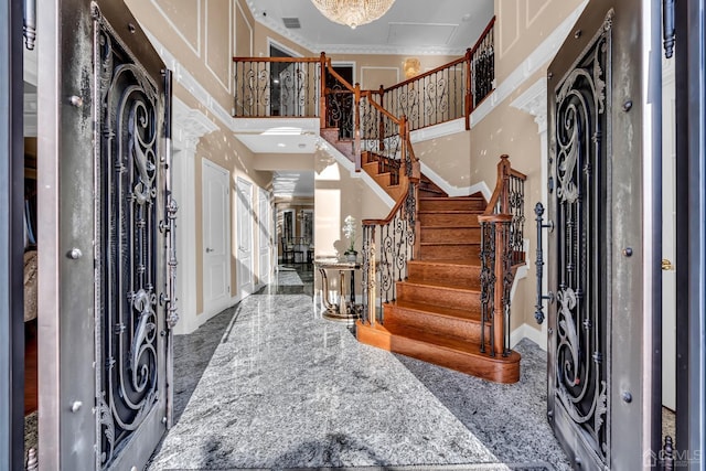 foyer entrance featuring granite finish floor, visible vents, a towering ceiling, stairs, and baseboards