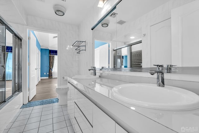 full bath with a shower with door, a sink, visible vents, and tile patterned floors