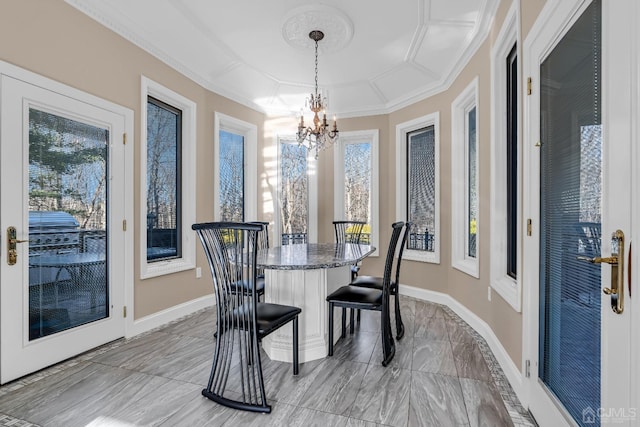 dining space with crown molding, a healthy amount of sunlight, and a notable chandelier