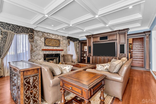 living room with beam ceiling, crown molding, a fireplace, and coffered ceiling