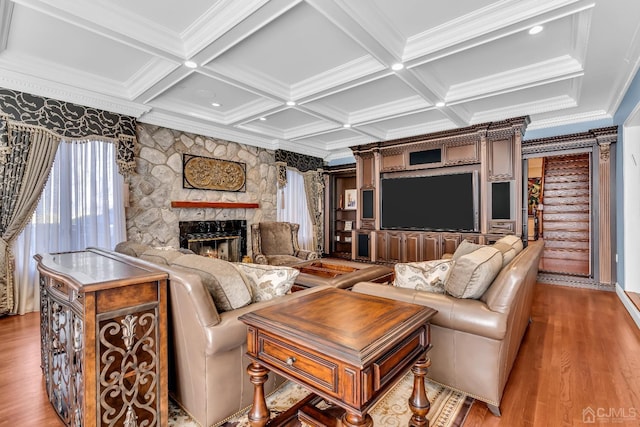 living area with crown molding, a fireplace, coffered ceiling, and wood finished floors