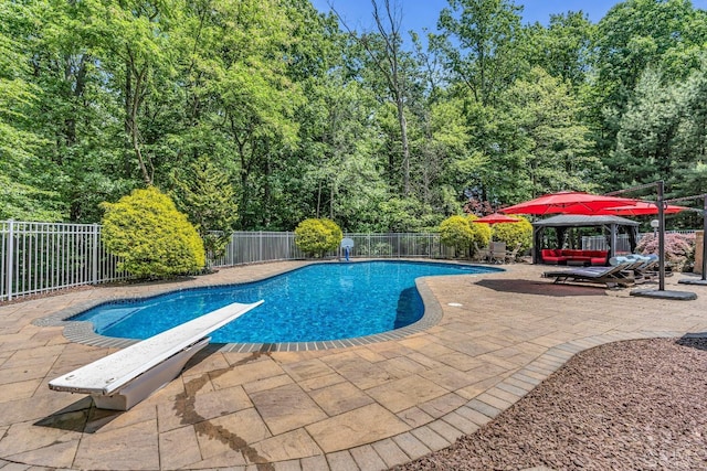 view of pool with a fenced backyard, a diving board, a fenced in pool, and a patio