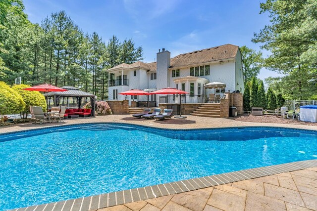 view of swimming pool featuring a gazebo, a patio area, an outdoor hangout area, and central air condition unit