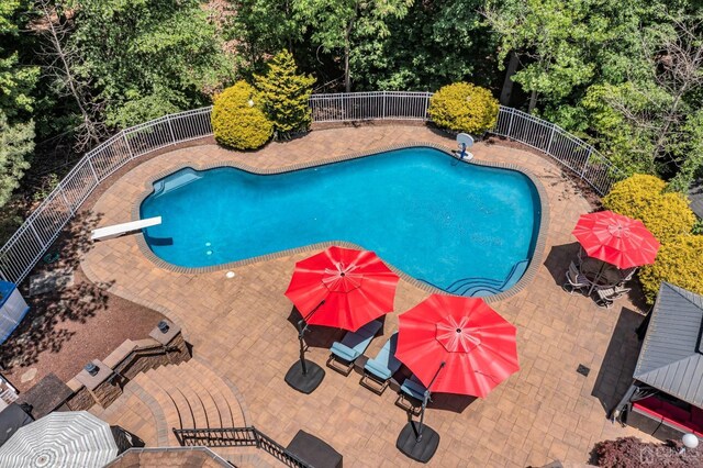 view of pool featuring a diving board and a patio