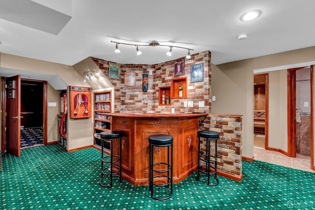 bar with a bar, carpet floors, baseboards, and track lighting