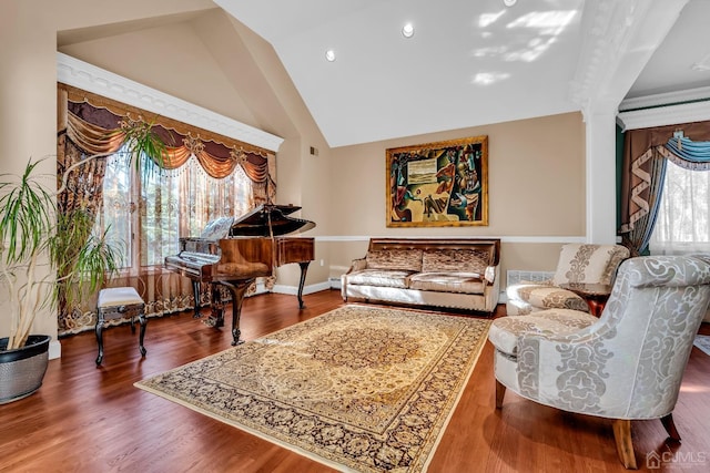 sitting room with ornate columns, plenty of natural light, baseboards, and wood finished floors