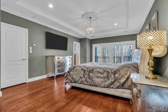 bedroom with crown molding, a raised ceiling, wood finished floors, access to outside, and baseboards