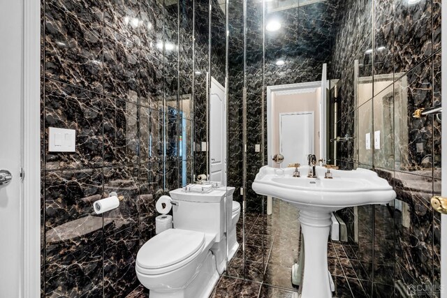 bathroom featuring tile walls and toilet