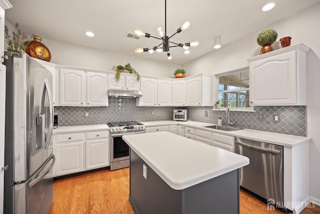 7 Cornell Dr, East Brunswick, NJ 08816 - kitchen with stainless steel appliances, a sink, under cabinet range hood, white cabinetry, and light wood-style floors
