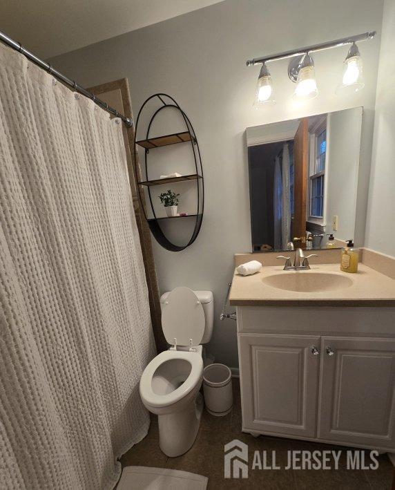 bathroom featuring tile patterned flooring, vanity, and toilet