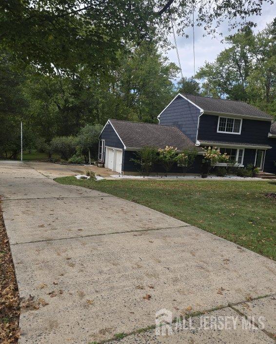 view of front of home with a front yard, an attached garage, and driveway