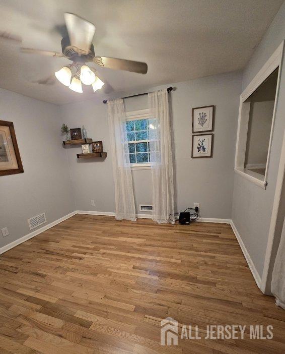 empty room with light hardwood / wood-style floors and ceiling fan