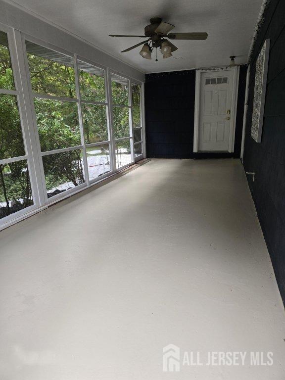 interior space featuring concrete floors and a ceiling fan