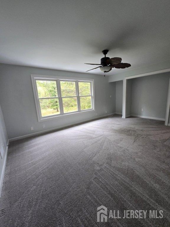 unfurnished room with ceiling fan, baseboards, and carpet floors