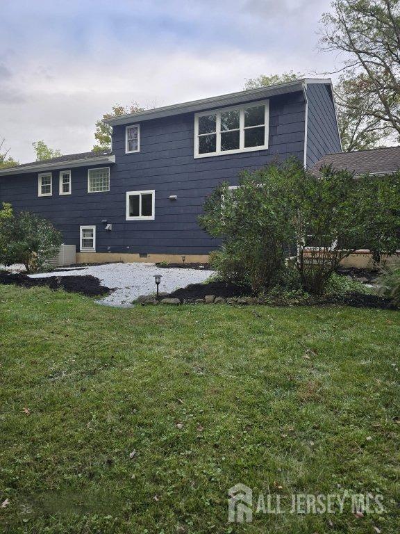 back of house featuring a lawn