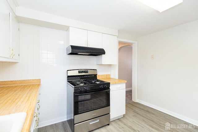 200 Plainfield Rd, Edison, NJ 08820 - kitchen featuring stainless steel gas stove, range hood, light wood finished floors, arched walkways, and white cabinetry