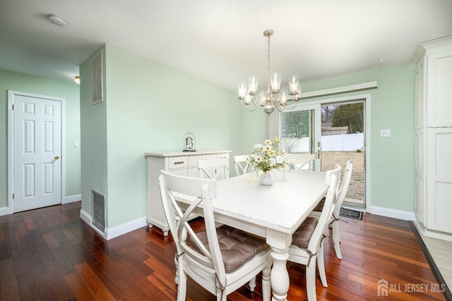 dining space with a notable chandelier, dark wood-style floors, visible vents, and baseboards