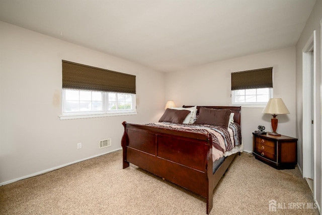 carpeted bedroom featuring visible vents