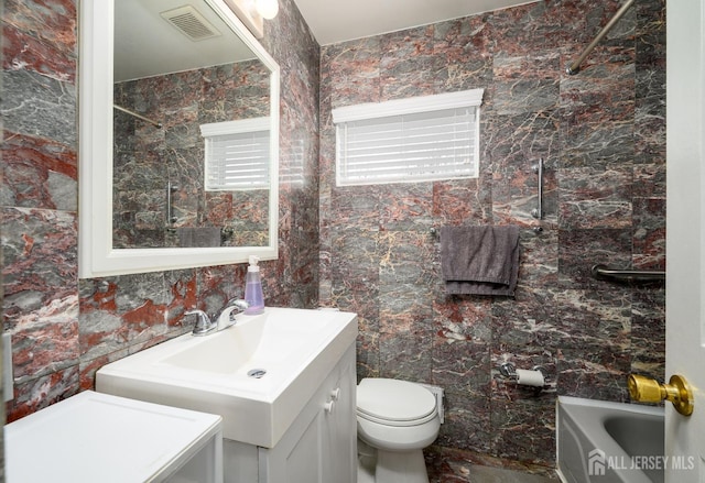 full bath featuring tile walls, visible vents, toilet, and vanity