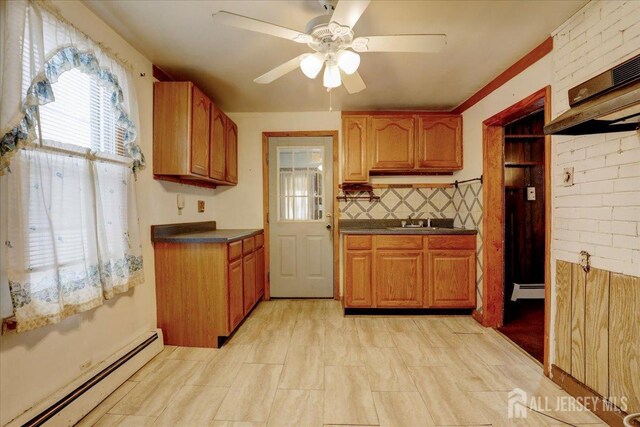 kitchen featuring a baseboard heating unit, ceiling fan, and tasteful backsplash