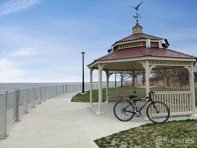 surrounding community with a water view and a gazebo