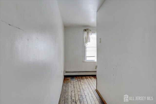 hallway with a baseboard heating unit and hardwood / wood-style flooring