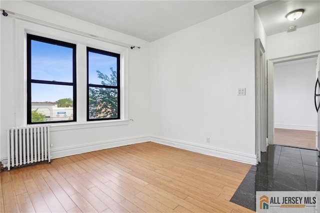 57 Corbin Ave Unit 24, Jersey City, NJ 07306 - spare room featuring radiator heating unit and light wood-style floors