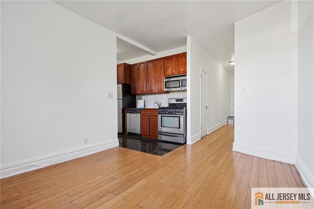 57 Corbin Ave Unit 24, Jersey City, NJ 07306 - kitchen with stainless steel appliances, light wood-type flooring, and decorative backsplash
