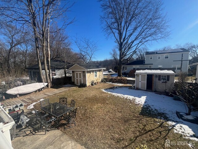 snowy yard with a storage shed