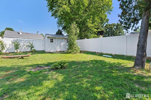 view of yard featuring a storage shed, an outdoor structure, and a fenced backyard