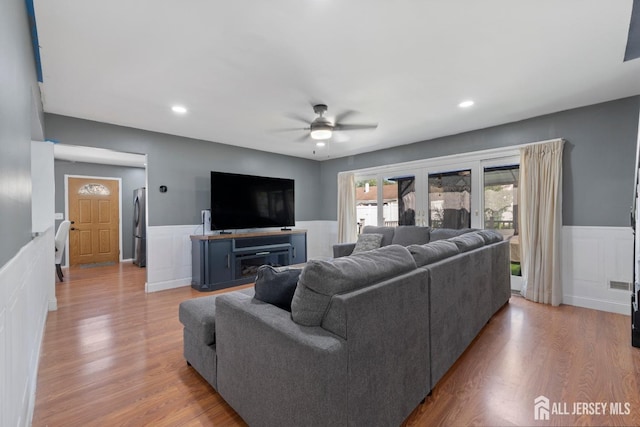 living area with a wainscoted wall, recessed lighting, a decorative wall, ceiling fan, and wood finished floors