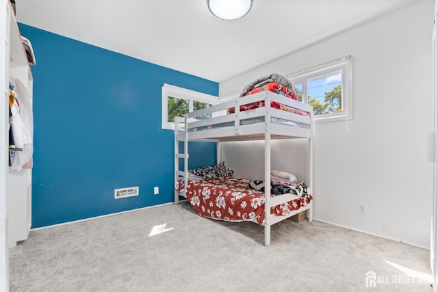 bedroom with carpet floors and multiple windows