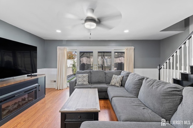 living room featuring recessed lighting, stairway, wainscoting, and light wood-style floors